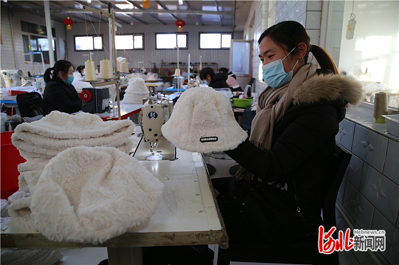 图2：工人在检验自己缝制的帽子。吴海民摄.jpg