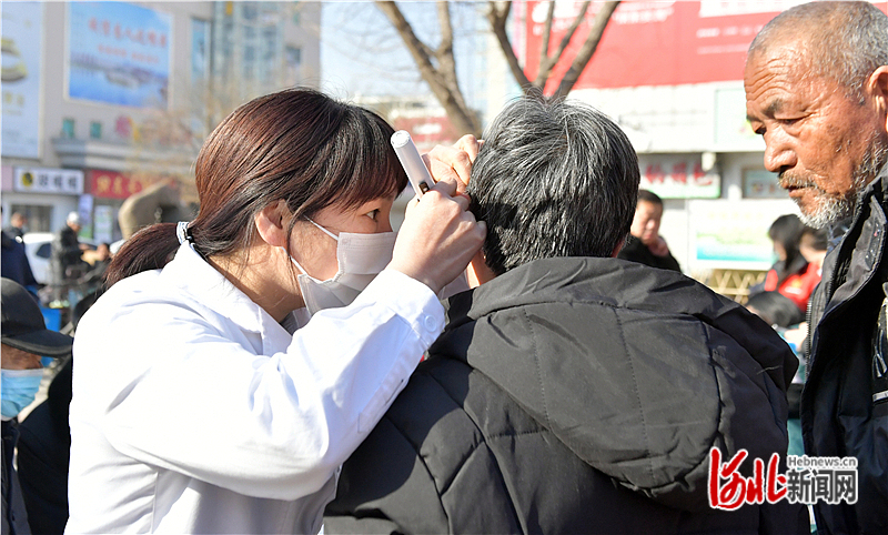 图4：3月3日，在迁安市文化广场，医护人员在为老人免费检查鼓膜、耳道。.jpg