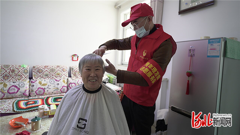 图3：在迁西县滨河社区滨河家园小区，青年理发师志愿者为老人义务理发。.jpg