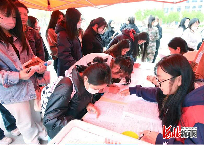 图4：活动现场，师生们向志愿者咨询献血注意事项。.jpg