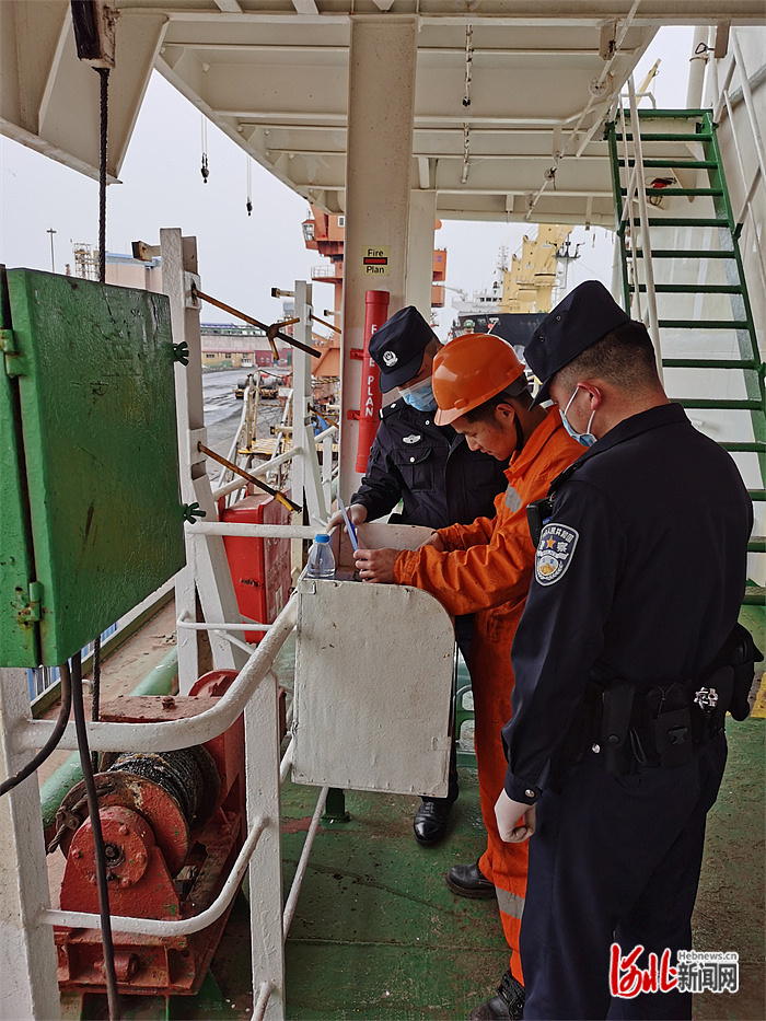 图为唐山边检民警正在对船员登记信息进行检查.jpg