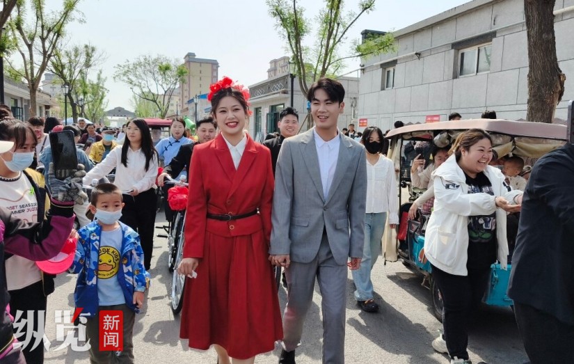 5月2日，一对新人走在冀州老街。他们用上世纪八十年代的风俗举办婚礼，引来众多游客围观祝福。 河北日报记者 邢云摄.jpg