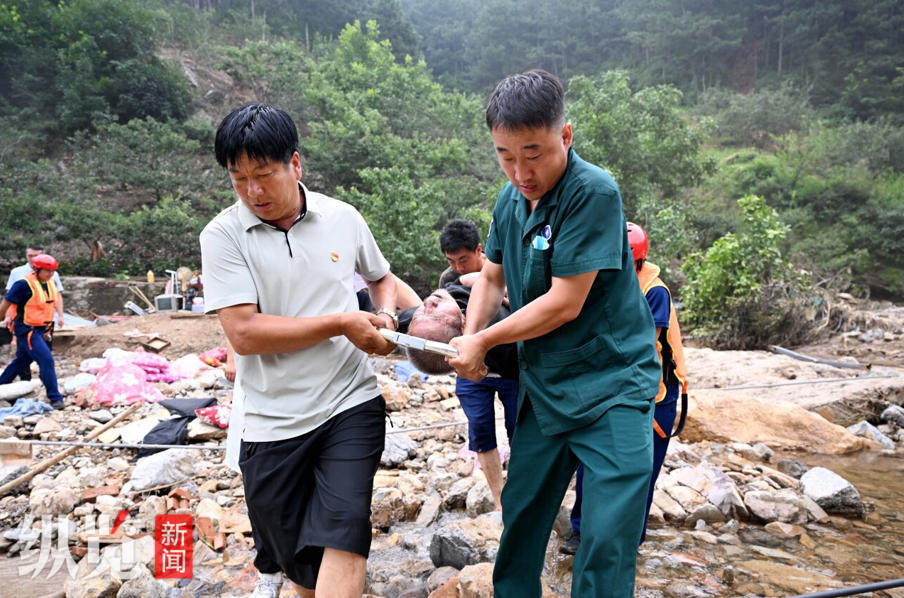 8月2日，商桂福（前排左一）和救援人员抬着担架，送行动不便的村民搭乘救护车转往安置点。  河北日报见习记者 张昊摄.JPG